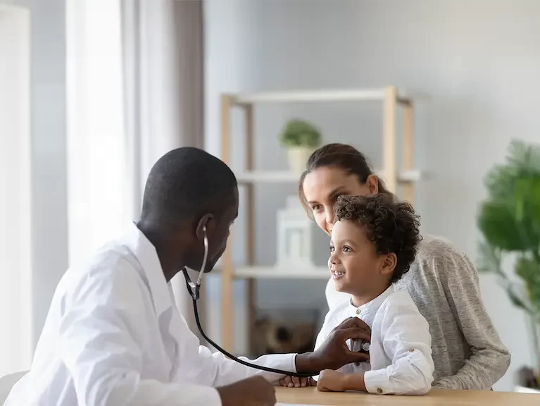 Locum tenens physician serving a rural community by performing check ups on a family in a doctor's office