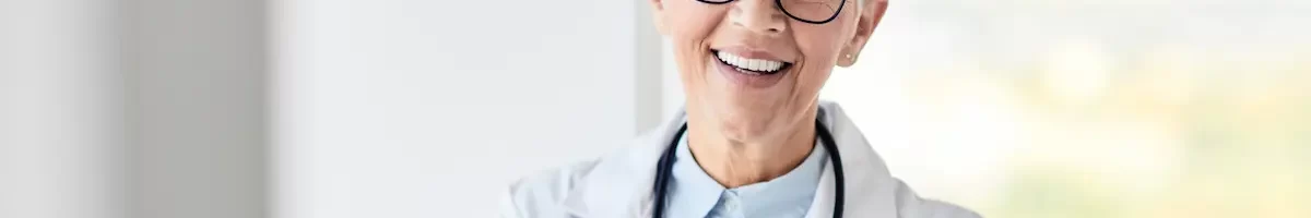 Older locum tenens physician smiling while crossing her hands