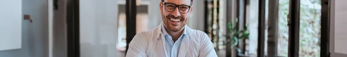 Locum Tenens physical smiling while working on his laptop in an office