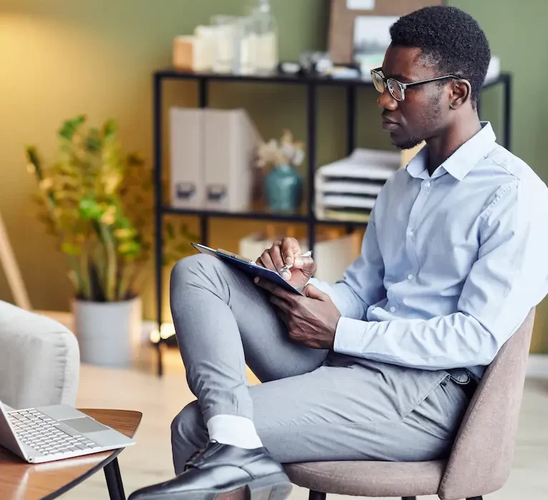 Locum tenens Psychiatrist sitting and taking notes during an online therapy session