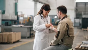 Locum Occupational Medicine professional bandaging a warehouse worker while at the workplace