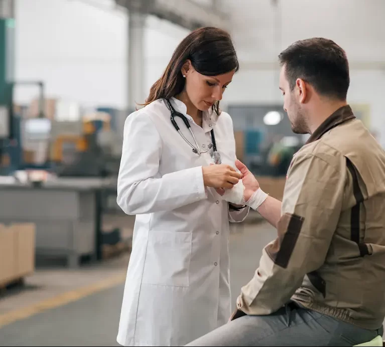 Locum Occupational Medicine professional bandaging a warehouse worker while at the workplace