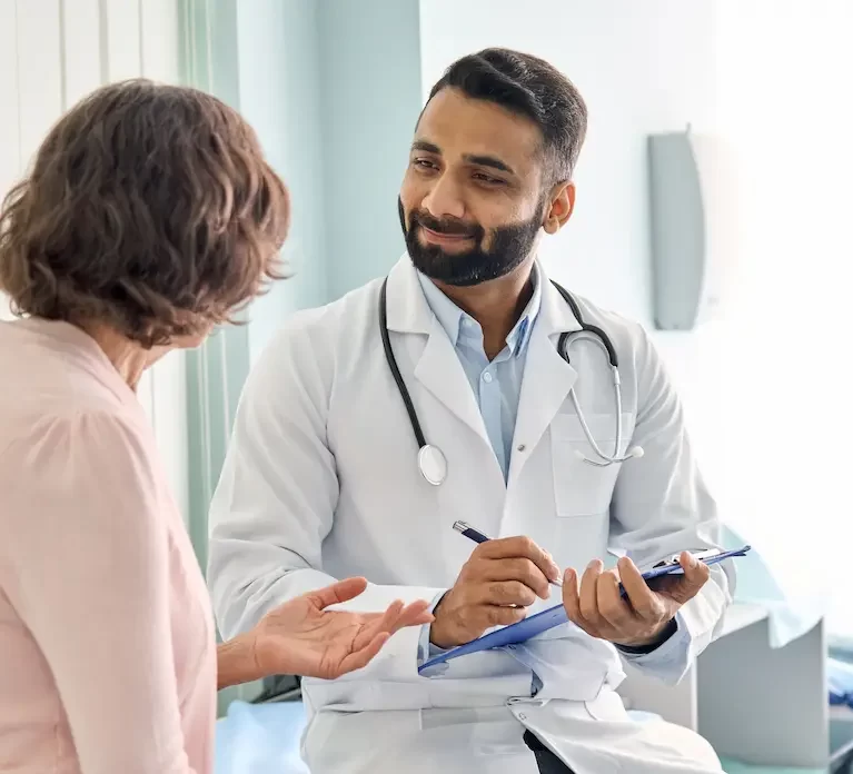 Locum tenens physician sitting in a doctor's office listening to a patient speak