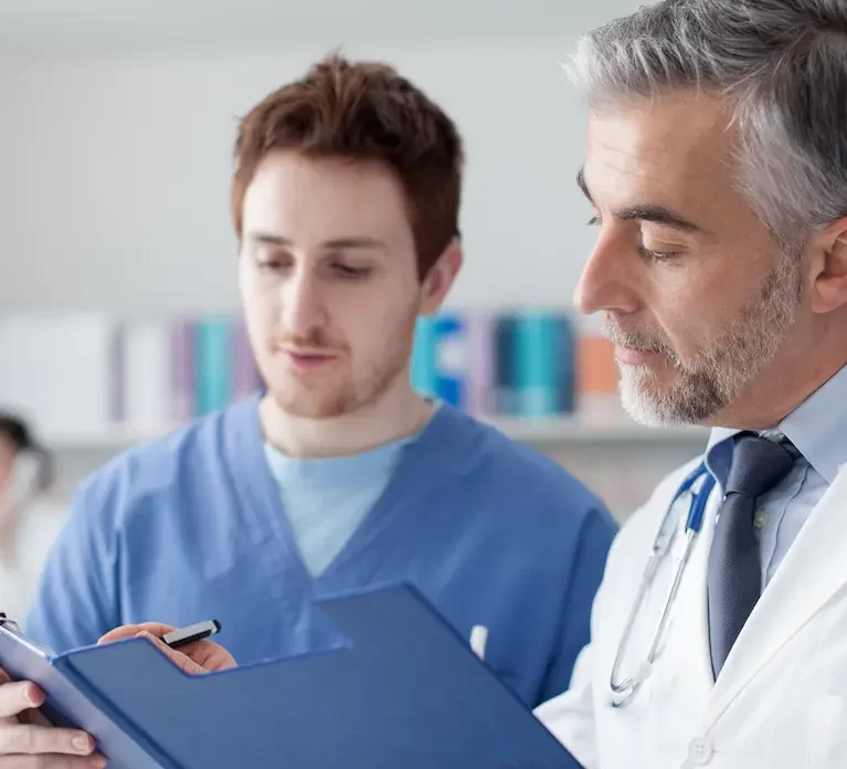 Locum tenens physician assistant standing and examining a folder with a physician