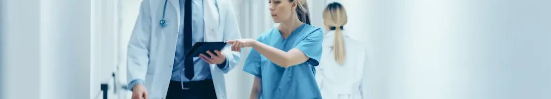 Locum PA and MD looking at papers while walking down a hallway