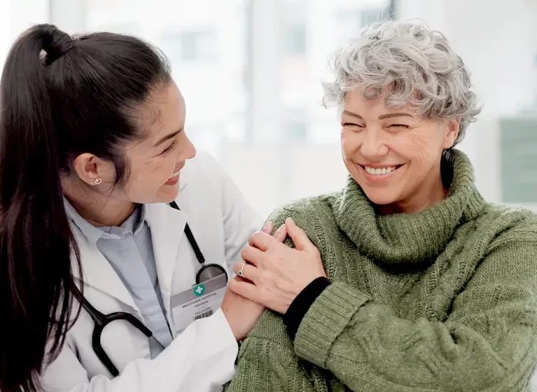Locum tenens physician smiling with and comforting a patient