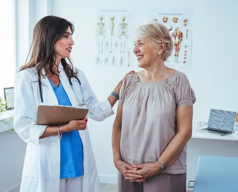 Locum tenens physician speaking to an elderly patient in a doctor's office.